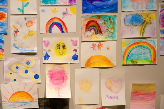 Collection of colorful children's drawings on a wall