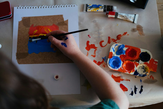 Child painting a colorful abstract artwork with watercolors